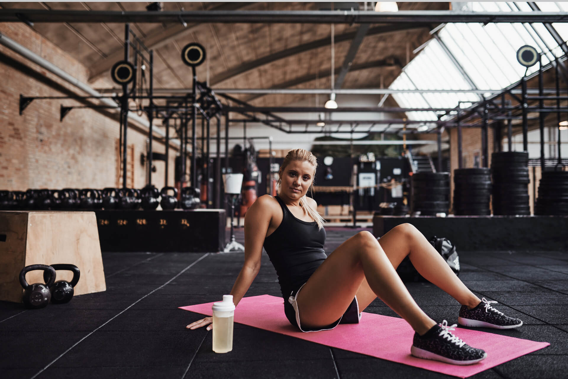 young-woman-sitting-on-a-gym-floor-after-working-o-2023-11-27-05-28-16-utc-1-1