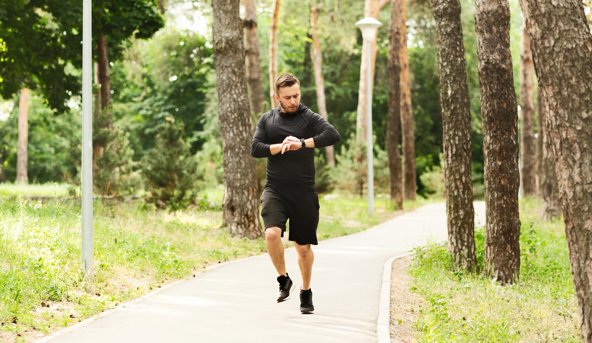 millennial-man-jogging-with-fitness-bracelet-and-checking-his-performance