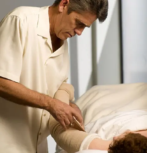 A Professional Therapist Performing Manual Lymphatic Drainage On A Patient&Amp;Apos;S Leg During A Physiotherapy Edmonton Session At In Step Physical Therapy. A Professional Therapist Performing Manual Lymphatic Drainage On A Patient&Amp;Apos;S Leg During A Physiotherapy Edmonton Session At In Step Physical Therapy.