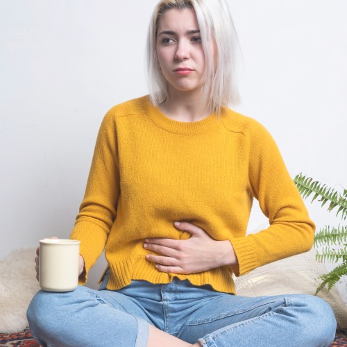 A Woman Sitting And Holding Her Abdomen In Discomfort, Illustrating The Need For Professional Pelvic Health Or Visceral Assessment During Physiotherapy Edmonton At In Step Physical Therapy. A Woman Sitting And Holding Her Abdomen In Discomfort, Illustrating The Need For Professional Pelvic Health Or Visceral Assessment During Physiotherapy Edmonton At In Step Physical Therapy.