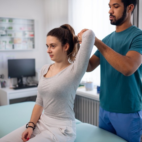 A Young Male Physical Therapist Performing A Clinical Assessment On A Female Patient&Amp;Apos;S Arm, Demonstrating Professional Diagnostic Techniques During Physiotherapy Edmonton At In Step Physical Therapy. A Young Male Physical Therapist Performing A Clinical Assessment On A Female Patient&Amp;Apos;S Arm, Demonstrating Professional Diagnostic Techniques During Physiotherapy Edmonton At In Step Physical Therapy.